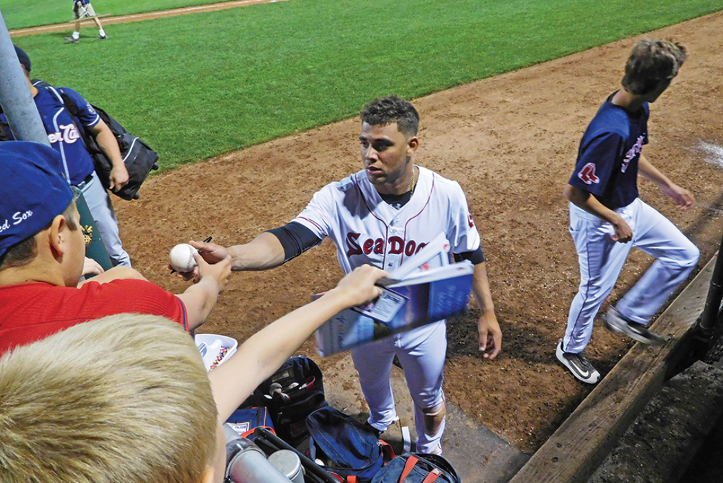 baseball player giving ball to crowd