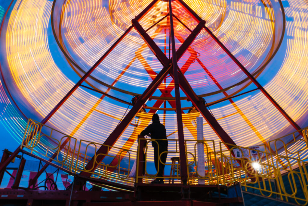 A carnival worker mans the Ferris wheel on the opening night of the Fryeburg Fair.
