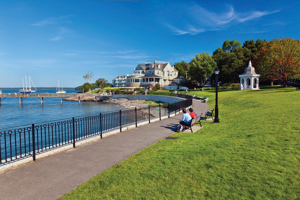 people sitting on bench next to coast