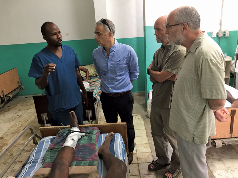 A resident at Justinien University Hospital reviews a case with Konbit Sante staff and physician volunteers.